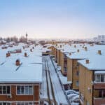 Snow covered roofs of houses in winter. City panorama, top view